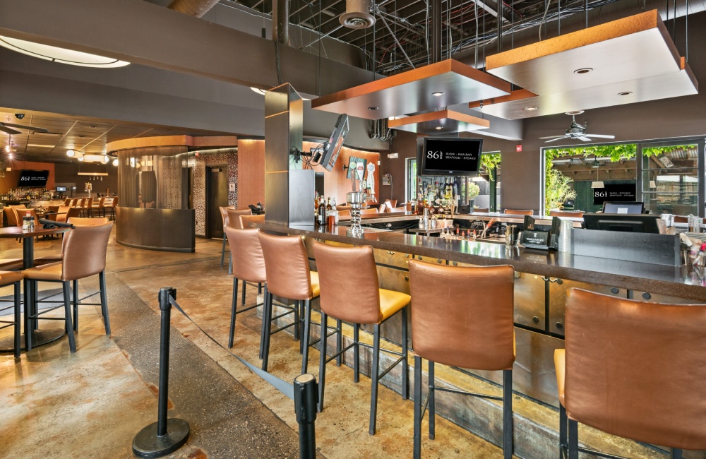 A restaurant with a large bar and stools.